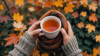 Person with scarf and tea in autumn